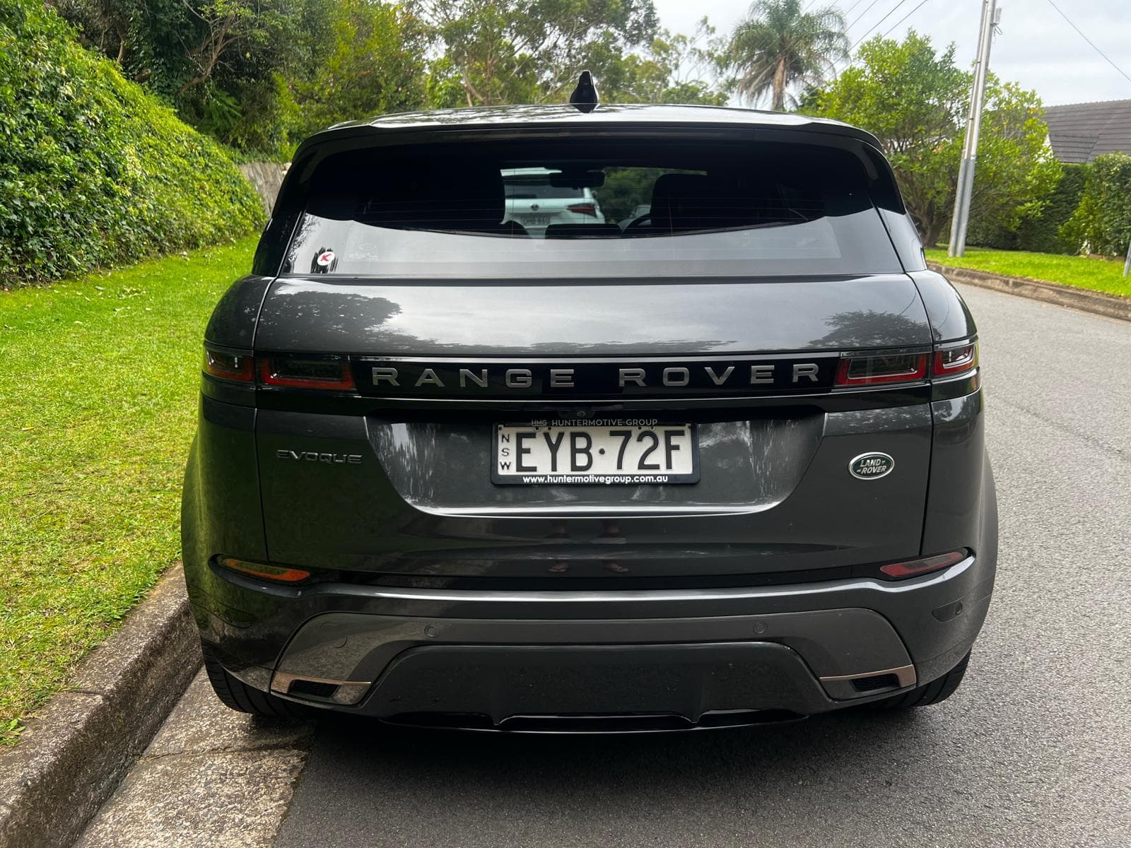 A Range Rover Evoque parked kerbside, photographed from the rear.